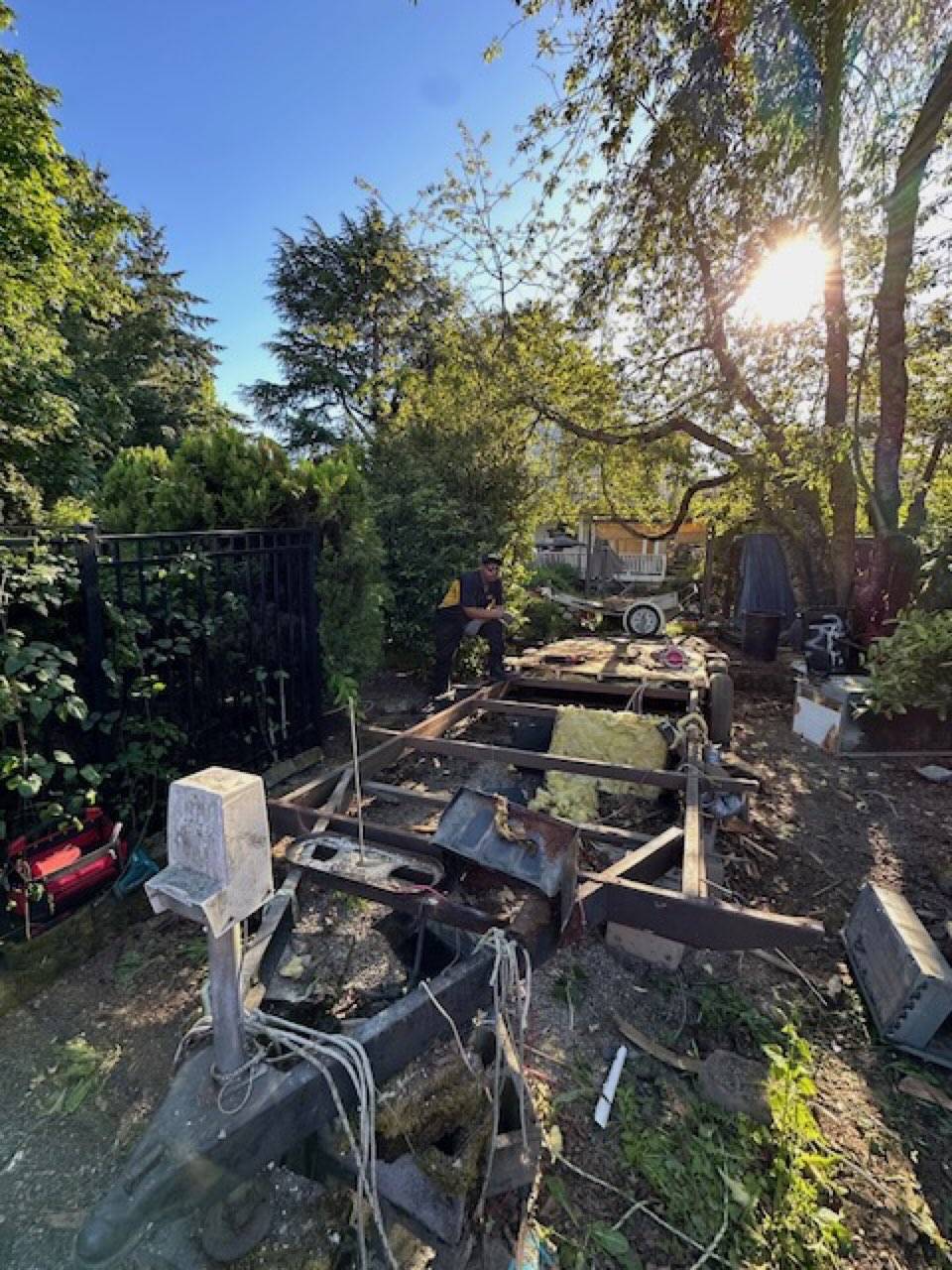 Junk B Gone crew dismantling the trailer frame on site